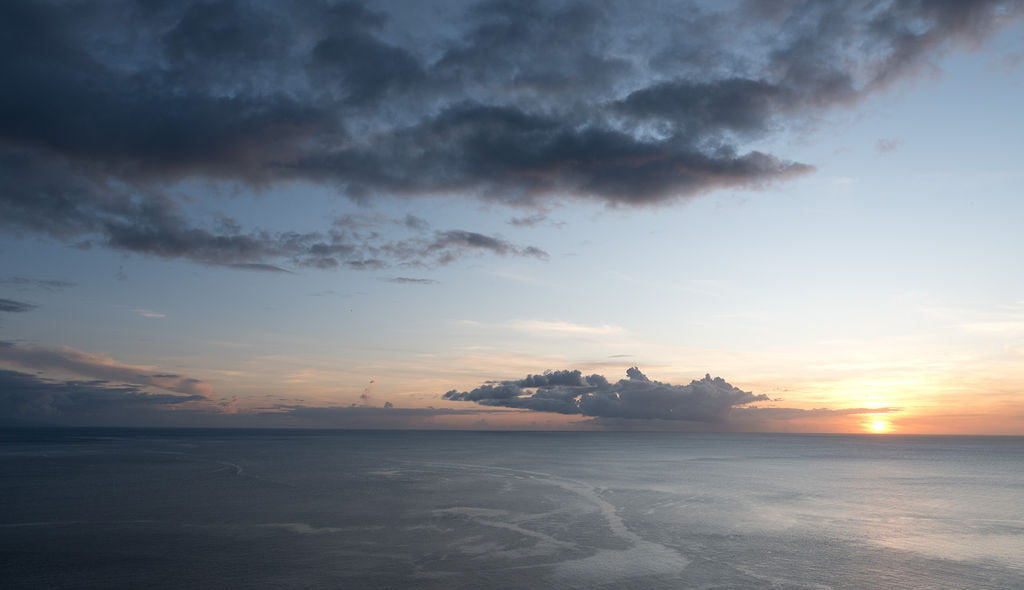 A grey blue and peachy sunset over the Caribbean sea, viewed from Cosmos St Lucia