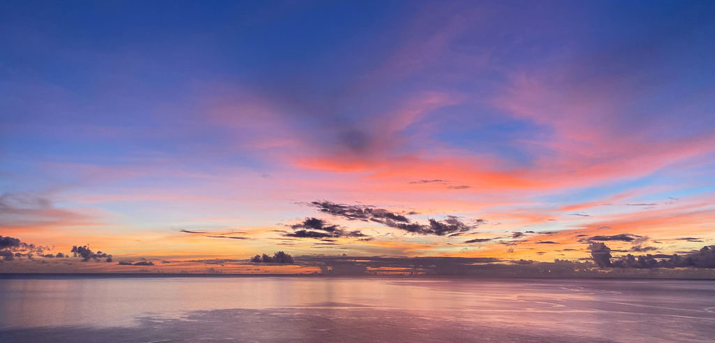 a sunset sky painted blue, pink, red, orange, yellow and violet, at Cosmos St Lucia