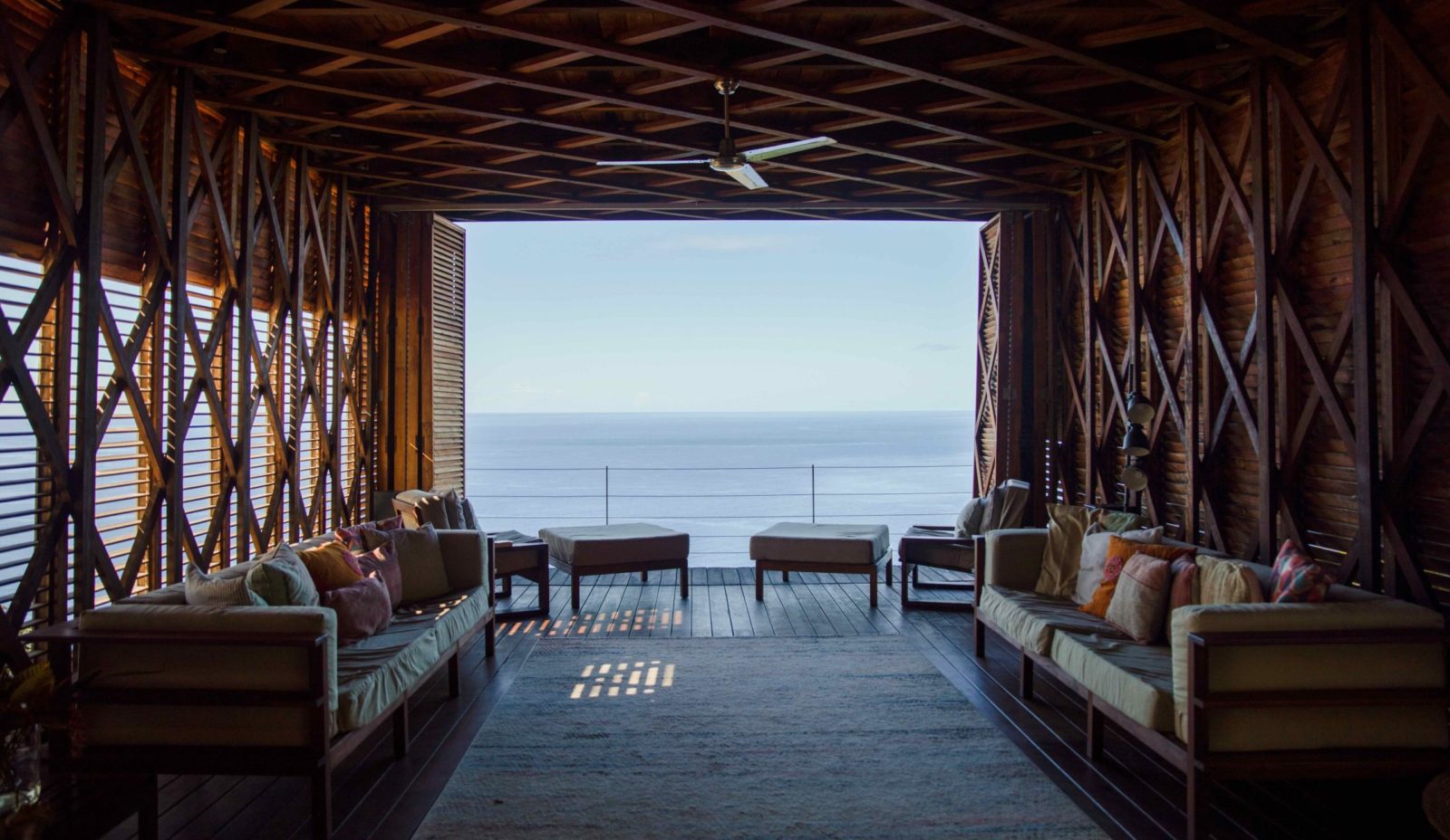 An interior view of the wooden Cantilever structure that forms the heart of Cosmos St Lucia. Showing relaxed seating and a view of the Caribbean Sea