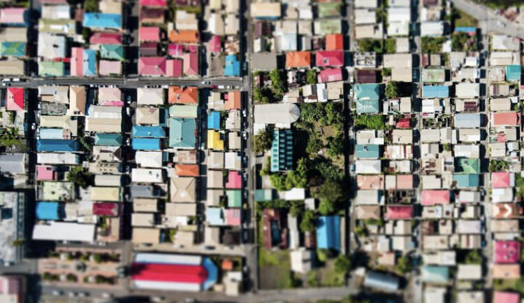 An aerial view of the colourful houses of Soufriere, appearing as small rectangles in different colourful Caribbean colours